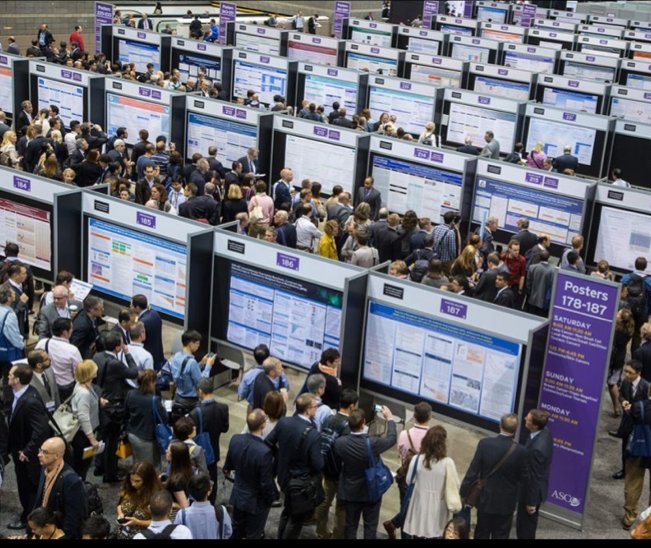 Attendees discussing research at a busy conference poster session